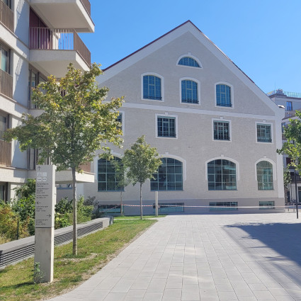 Hinweisschilder bei der Kuvertfabrik, die den Weg zum öffentlichen Nahverkehr und den umliegenden Wohnhäusern weisen.